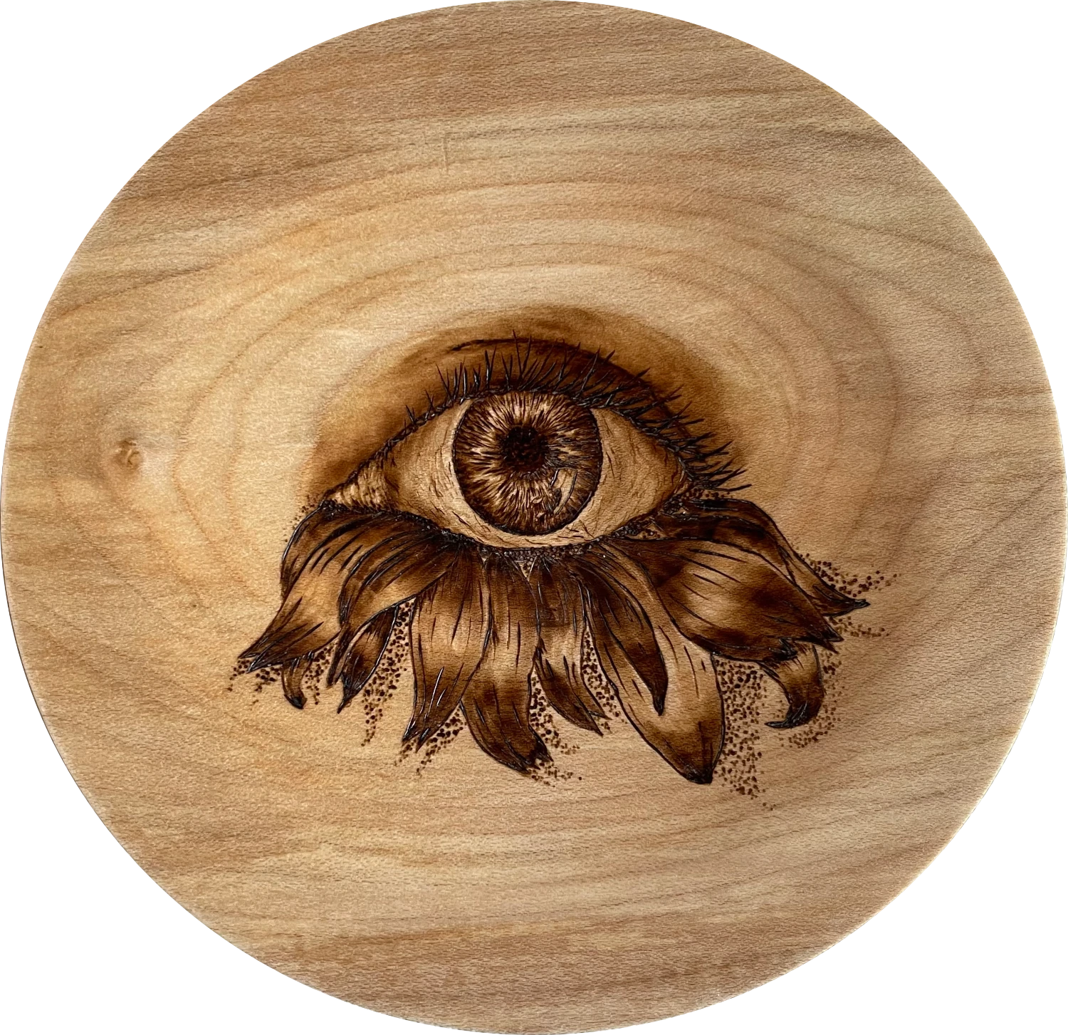 a medium sized bowl with an eye drawn in the centre using pyrography